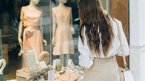 persona che guarda vetrine di un negozio con espressione pensierosa