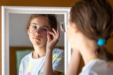 Adolescente con disabilità che guarda nello specchio con espressione confusa