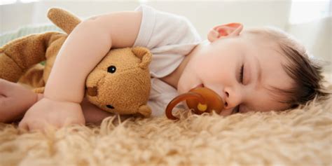 Un bambino che gioca con un oggetto transizionale (orsacchiotto)