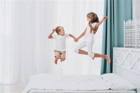Bambini che saltano su materassi in una stanza psicomotoria