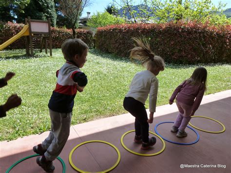 Bambini che saltano attraverso cerchi disposti a terra