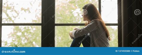 Ragazza che guarda pensierosa fuori dalla finestra