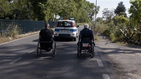 un poliziotto in sedia a rotelle che parla a un gruppo di persone