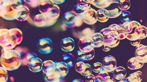 Una persona che cerca di afferrare delle bolle di sapone, che scivolano via