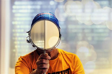 Persona che osserva il proprio riflesso distorto in uno specchio