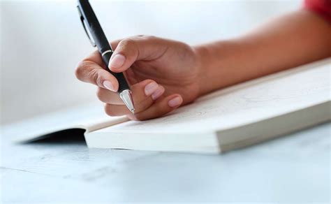 Persona che scrive su un diario, circondata da simboli di lavoro e vita personale