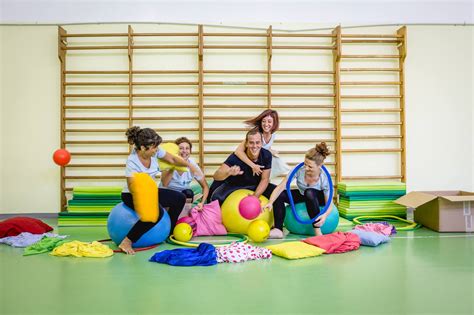 Bambini che giocano in un'aula di psicomotricità con materassini e palloni