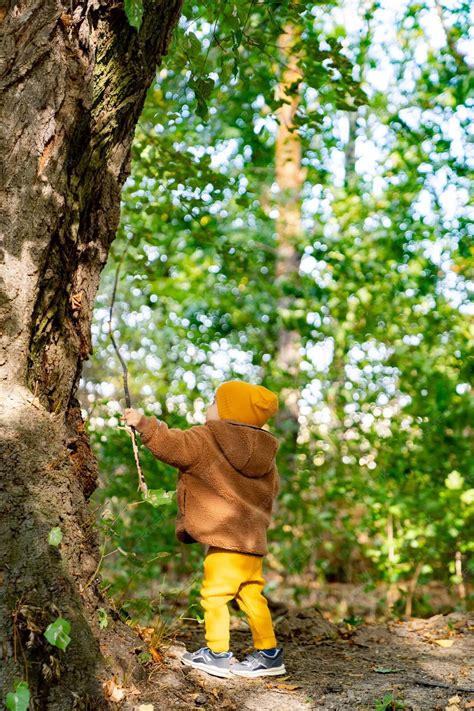 Bambino che cammina su un tronco d'albero in un parco
