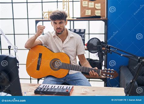 Un uomo che suona la chitarra in uno studio di registrazione