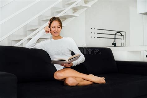 Donna incinta che legge un libro sul divano