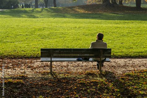 Persona seduta da sola su una panchina in un parco