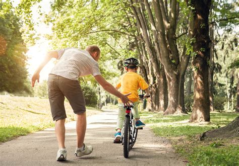 Bambino e adulto che imparano ad andare in bicicletta insieme