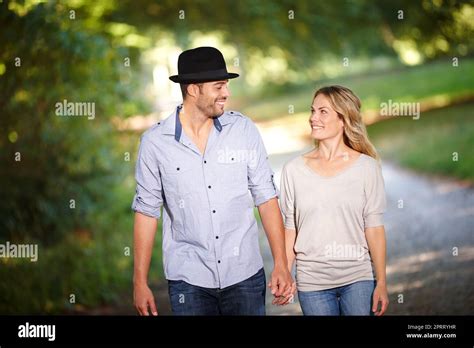 Coppia che cammina mano nella mano in un parco