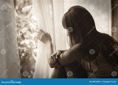 persona triste che guarda fuori dalla finestra