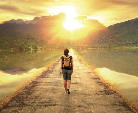 persona che cammina su un sentiero verso un orizzonte luminoso