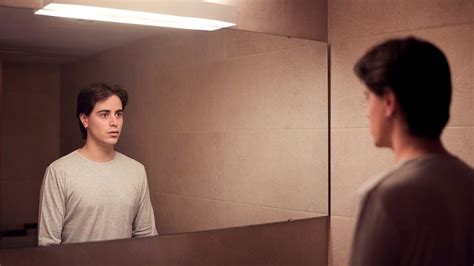 persona che scruta preoccupata uno specchio