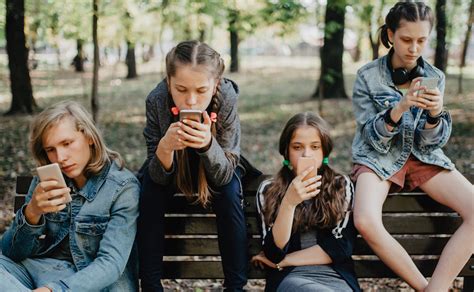 Gruppo di adolescenti che guardano i propri smartphone invece di interagire
