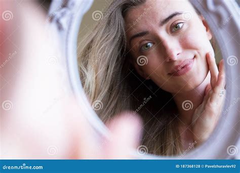 ragazza che si guarda allo specchio con preoccupazione