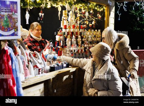 Persone che scelgono regali in un mercato natalizio affollato