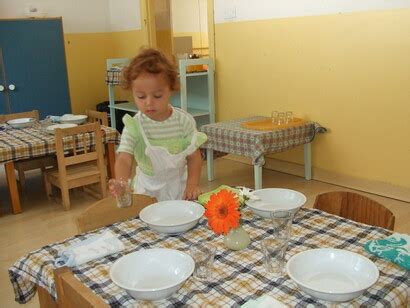 Bambino che apparecchia la tavola con l'aiuto di schede visive