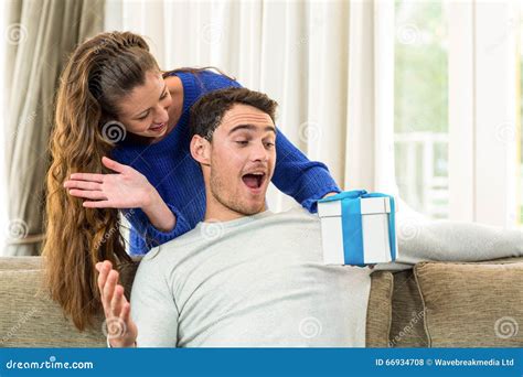 Uomo che riceve un regalo con espressione ambigua