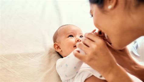 Mamma che massaggia il suo neonato con un sorriso