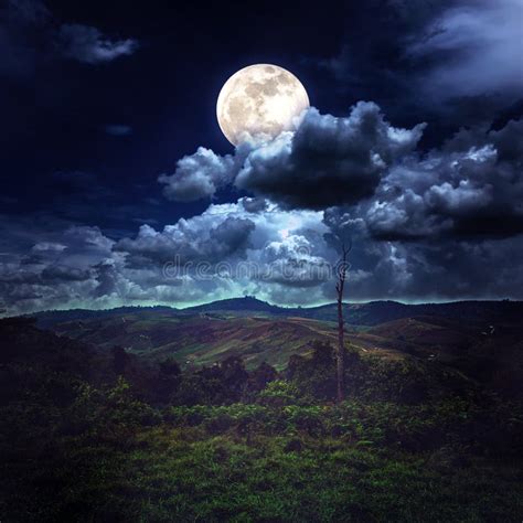 La luna nel cielo notturno sopra un paesaggio collinare