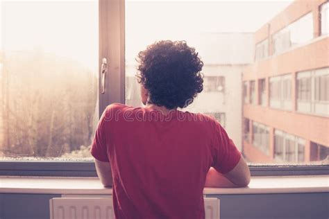 Ragazzo pensieroso che guarda fuori dalla finestra