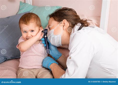 Pediatra che esamina l'orecchio di un bambino con un otoscopio
