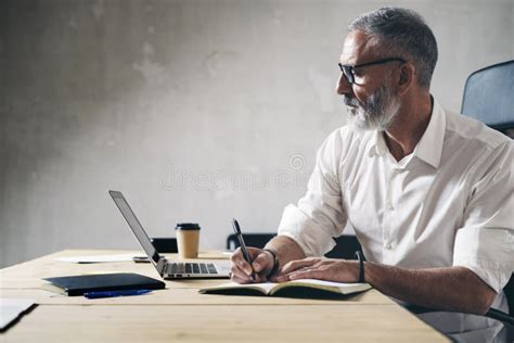 Adulto che lavora al computer con appunti sparsi