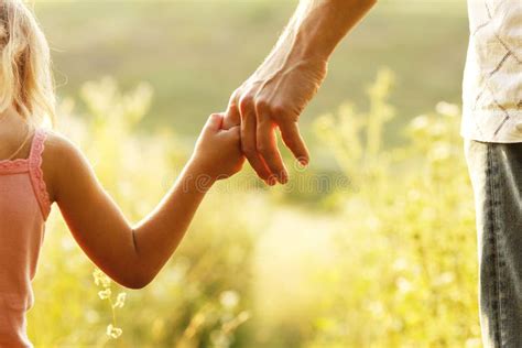 un genitore che tiene la mano di un bambino con autismo