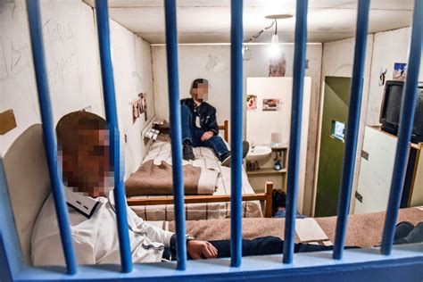 Una cella di prigione con un detenuto che legge