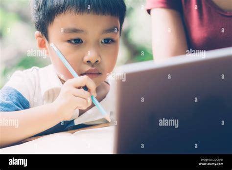 Vista di un bambino che utilizza un tablet per studiare con un'espressione concentrata